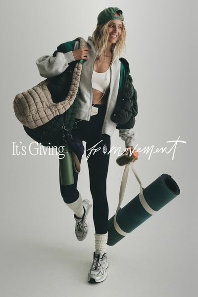 A high-quality lifestyle shot featuring a model in athleisure gear carrying a gym bag and yoga mat, emphasizing a curated, active brand aesthetic.