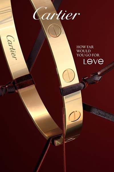 A high-end product creative featuring a gold bracelet intertwined with thin leather cords against a deep, dramatic red background.