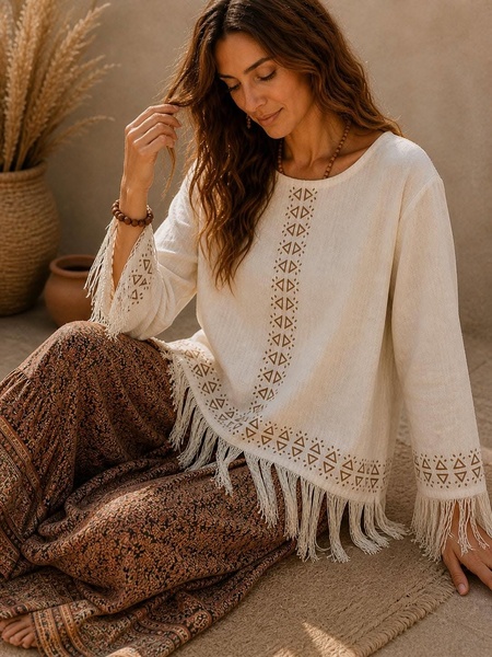 A high-quality lifestyle shot featuring a model in a beige fringed linen top, emphasizing natural textures, neutral tones, and an artisanal boho aesthetic.