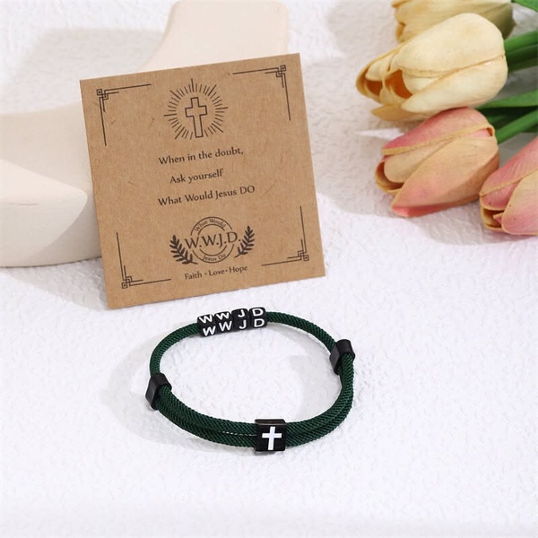 A close-up, high-angle lifestyle shot featuring a woven bracelet with faith-based messaging on a small accompanying card.