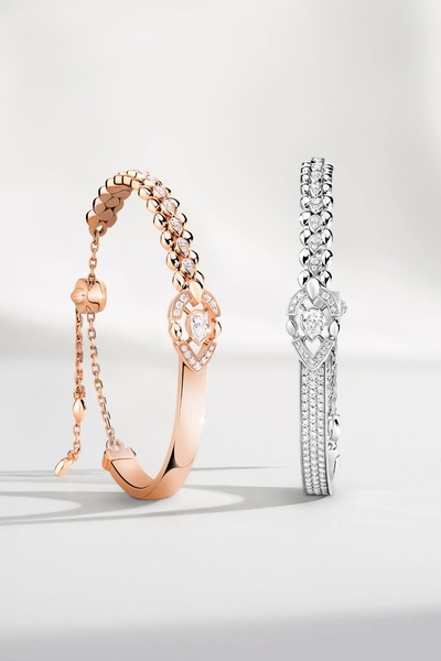 A high-end, clean studio product shot featuring two luxury bracelets in rose gold and white metal finishes, positioned symmetrically against a soft white background.