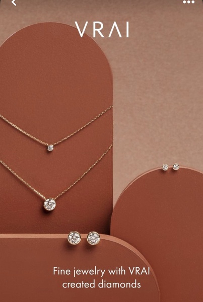 A refined product-focused display of gold chains and diamond stud earrings arranged on modern, earth-toned geometric shapes.