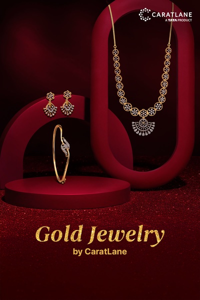 A high-end studio display featuring a gold necklace, earrings, and bracelet arranged against a deep red velvet backdrop.