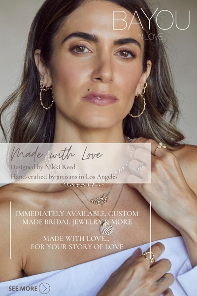 A close-up portrait of a model wearing layered delicate jewelry, focusing on the craftsmanship and personal connection to the brand.