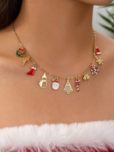 A close-up shot of a gold charm necklace featuring various Christmas-themed icons on a model, set against a soft-focus festive background.