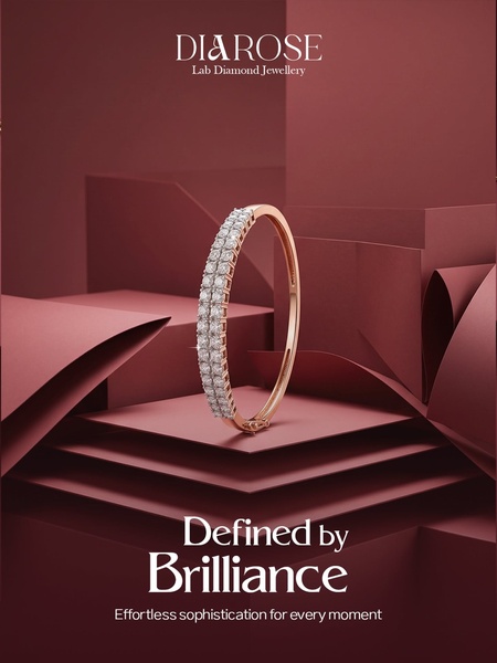 A high-end, minimalist studio photograph of a double-row diamond bracelet centered against deep burgundy geometric paper-art layers.