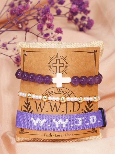 A high-quality product display featuring a stacked W.W.J.D. bracelet set on a burlap display card, decorated with soft purple baby's breath flowers.