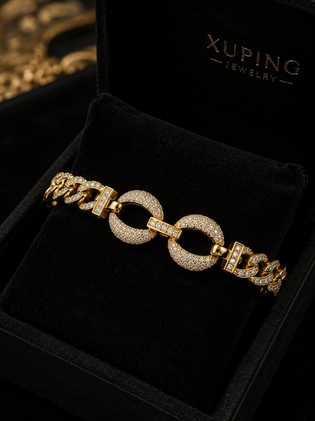 A close-up studio shot of a gold, diamond-encrusted chain link bracelet nestled in a black jewelry display box.
