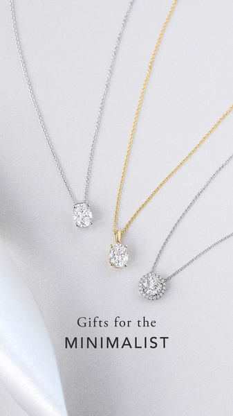 A high-end, clean product hero shot featuring three distinct necklaces on a neutral satin background, emphasizing minimalist gift appeal.