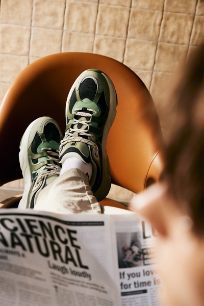 A top-down, first-person perspective showing the product in a comfortable, everyday setting, emphasizing the shoe's aesthetic and quality.