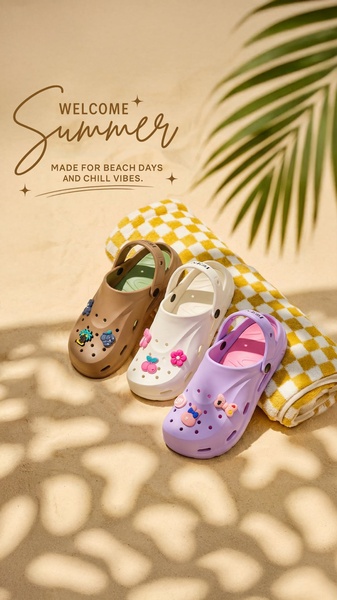 A high-quality lifestyle shot featuring three pairs of clog sandals decorated with charms on a beach towel atop sandy ground.