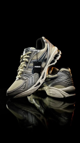 A high-end studio product shot of a running shoe placed on a reflective surface against a deep black background.