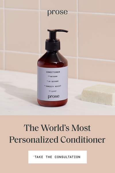 A high-contrast, minimalist shot of a personalized shampoo bottle placed in a neutral tiled bathroom environment.