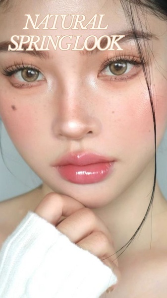 A close-up portrait of a model showcasing a glowing, natural spring makeup look with emphasis on hydrated, glossy lips.