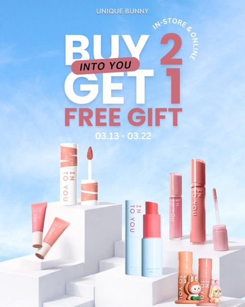 A promotional beauty ad featuring multiple lip care products arranged on clean white geometric blocks against a soft blue sky.