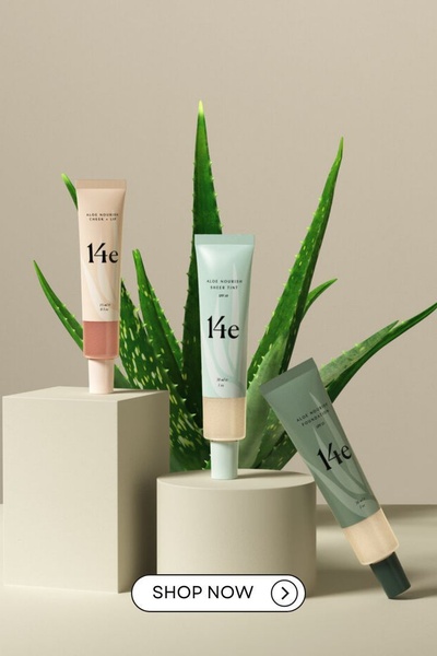 A minimalist studio shot featuring three skincare products arranged on pedestal blocks with a fresh aloe vera plant in the background.
