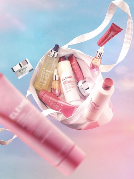 A top-down, airy perspective showing an array of skincare bottles and tubes floating above an ethereal, gradient background.