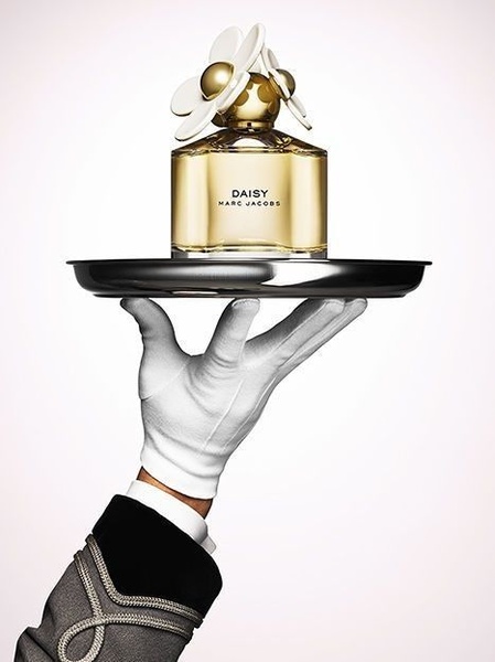 A high-end studio shot of a perfume bottle held on a silver platter by a gloved hand, emphasizing elegance and premium quality.