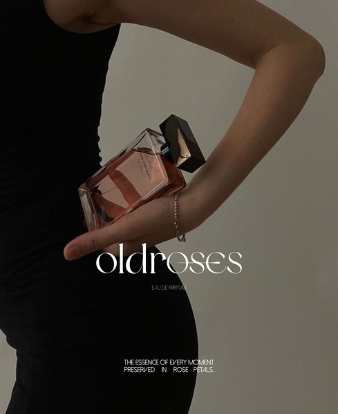 A high-end, minimalist lifestyle capture of a perfume bottle held in a natural, elegant position against a neutral, moody background.