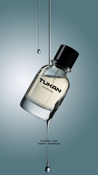 A high-end editorial product shot featuring a perfume bottle suspended in air with liquid trailing from the glass.