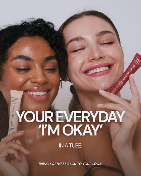 A close-up studio shot featuring two smiling models holding different shades of lip serum, emphasizing a natural, clean beauty aesthetic.