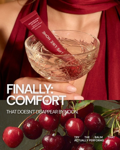 A close-up of a lip serum tube submerged in a crystal glass with a pile of cherries in the foreground, highlighting a luxurious, long-lasting product experience.