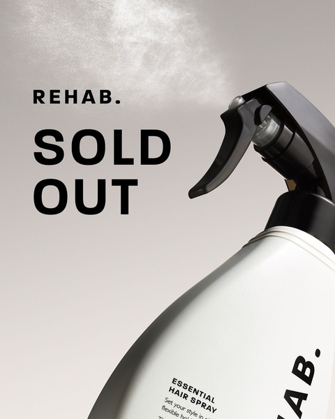 A high-end, minimalist product shot of a hair spray bottle captured in a mid-spray action sequence to emphasize professional quality.