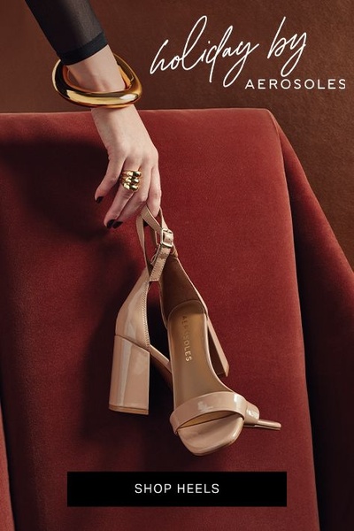 A high-end visual featuring a pair of elegant beige heels held delicately against a rich, warm-toned velvet background to convey holiday luxury.