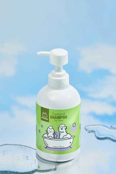A clean, high-contrast product shot of pet shampoo set against a sky-blue background with water splashes to convey freshness and natural ingredients.