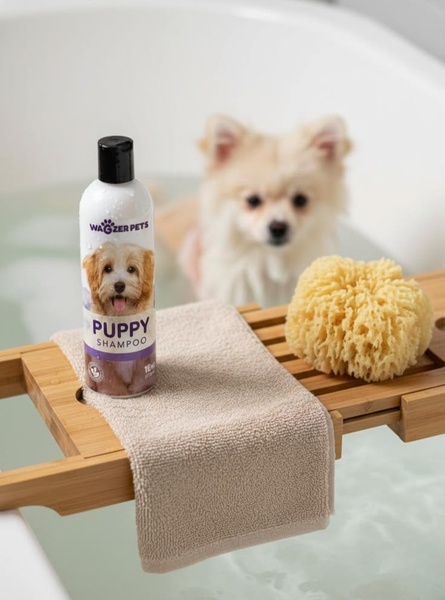 This ad creative features a bottle of puppy shampoo placed on a wooden bath caddy, with a soft-focus puppy in the background.