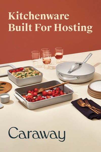 A clean, high-end lifestyle shot of kitchenware pans and plates arranged for a meal, emphasizing a 'Built For Hosting' value proposition.