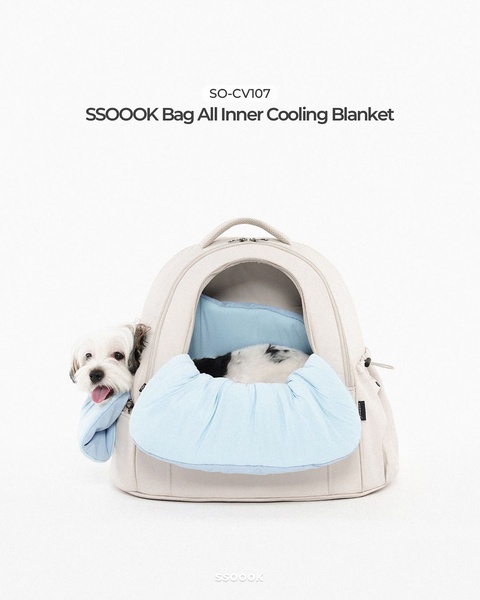 A minimalist, high-key studio photograph featuring a small dog inside a specialized pet carrier with a cooling blanket component.