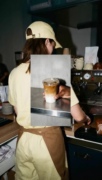 A close-up, split-screen aesthetic shot featuring a hand holding a fresh iced latte against a professional coffee machine setting.