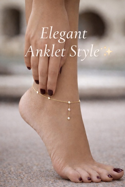 A close-up photograph of an elegant anklet on an ankle, emphasizing the delicate chain and pearls.