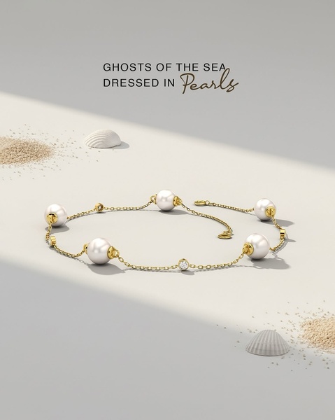 A high-end still life product shot featuring a pearl bracelet placed on a neutral, sandy surface with subtle lighting.