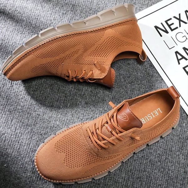 A clean, top-down product hero shot featuring a pair of brown casual walking shoes on a neutral grey textured background.