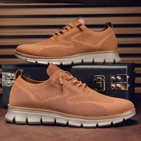 A clean, studio-lit photograph of a single pair of brown woven running shoes arranged on a dark, professional surface.