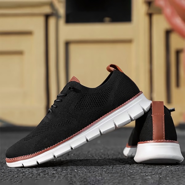 A clean, side-profile studio shot of a black running shoe on an asphalt surface, emphasizing texture and color contrast with a blurred architectural background.