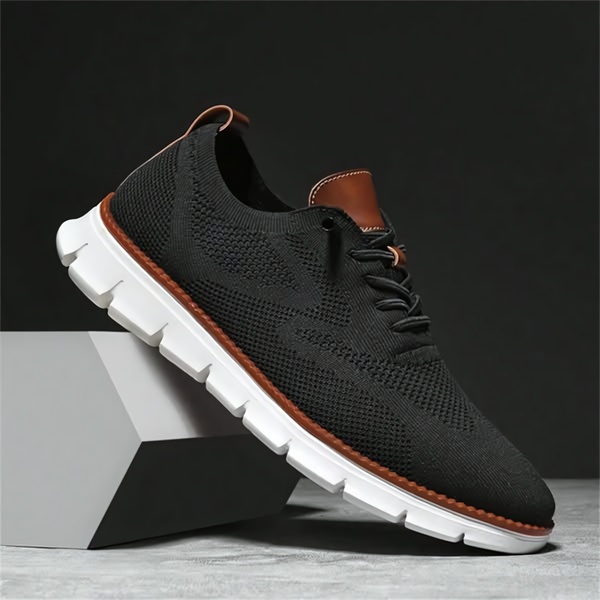 A high-contrast studio shot of a black knitted sneaker with a white platform sole resting on a geometric block, emphasizing clean lines and material texture.