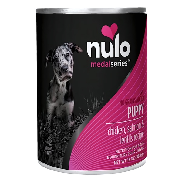 A high-contrast, professional product shot of a puppy food can featuring a puppy in the background, focusing on ingredient transparency.