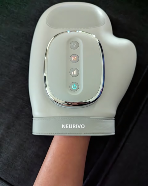A top-down, clean product shot of a heated hand massager focused on the control panel, highlighting the intuitive interface and sleek design.