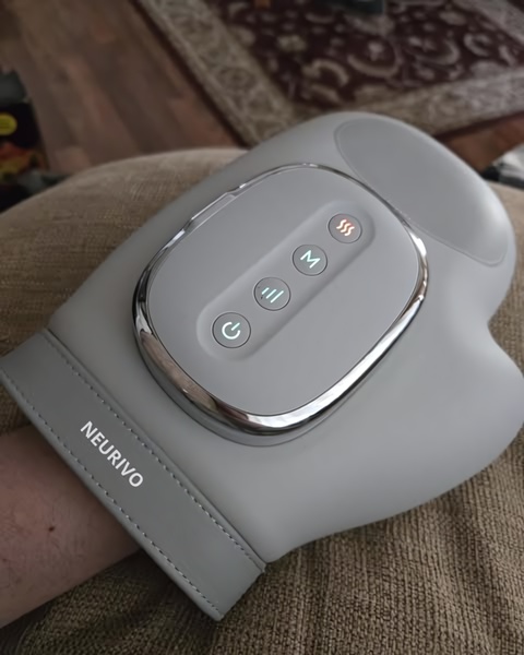 A close-up, high-angle shot of the Neurivo hand massager showing interface buttons and sleek industrial design.