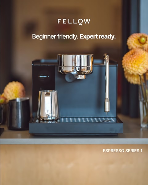 A high-end, clean product shot of an espresso machine on a kitchen counter with soft, natural lighting and floral accents, emphasizing a beginner-to-expert value proposition.