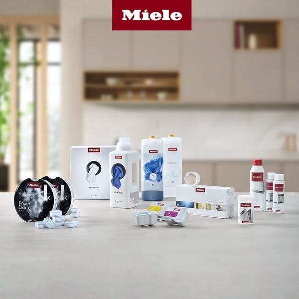 A high-end, studio-lit collection of various cleaning supplies arranged in a clean kitchen setting to highlight the premium nature of the products.