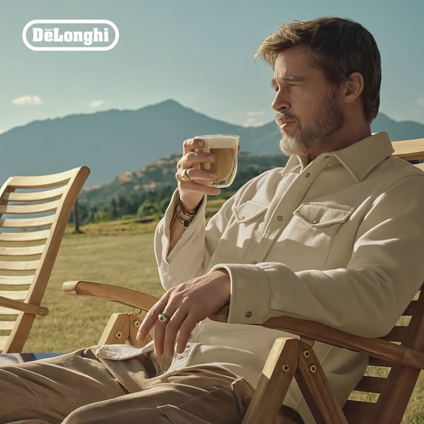A refined lifestyle shot of a man enjoying a fresh espresso coffee drink outdoors, establishing a premium product atmosphere.
