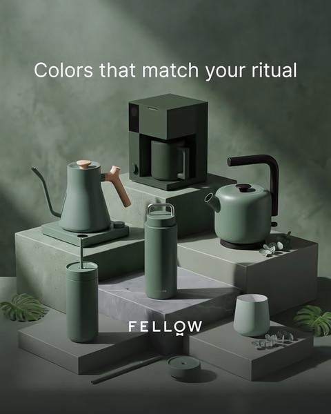 A high-end product photography display featuring a matching set of coffee-making appliances in a uniform, matte olive green color palette.