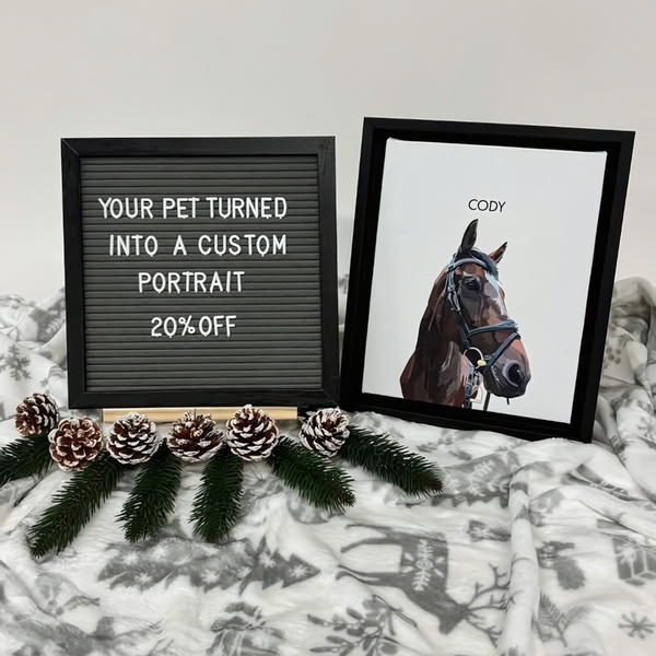 A clean, high-contrast flat lay featuring a framed custom pet portrait and a sign board with a 20% off promotion, styled with winter-themed pinecones.