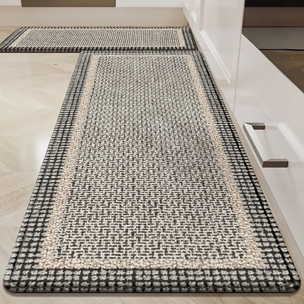 A top-down, angled shot of a textured, neutral-toned runner rug placed in a modern kitchen setting, highlighting the product's design in a real-life environment.