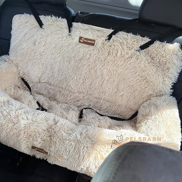A high-resolution, top-down shot of a plush, cream-colored pet car seat cover installed in a vehicle, highlighting comfort and premium quality.