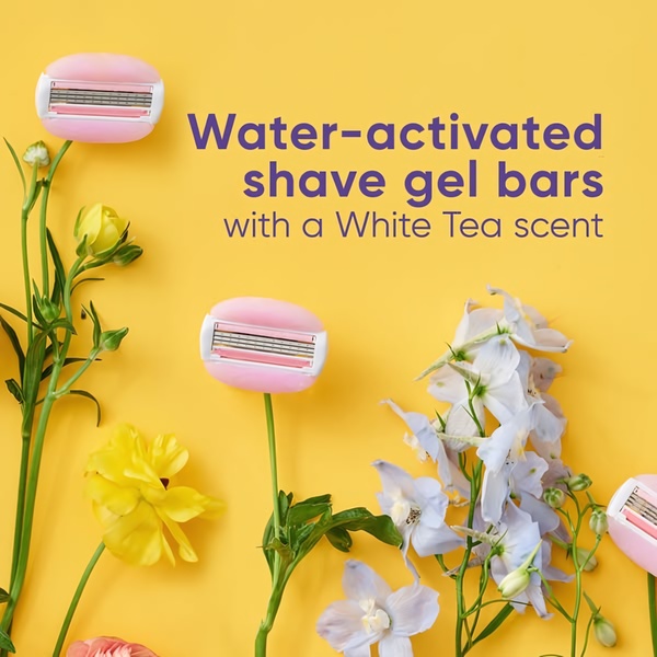 This ad features razor heads with integrated shave gel bars surrounded by flowers on a bright yellow background, emphasizing a gentle, scented experience.